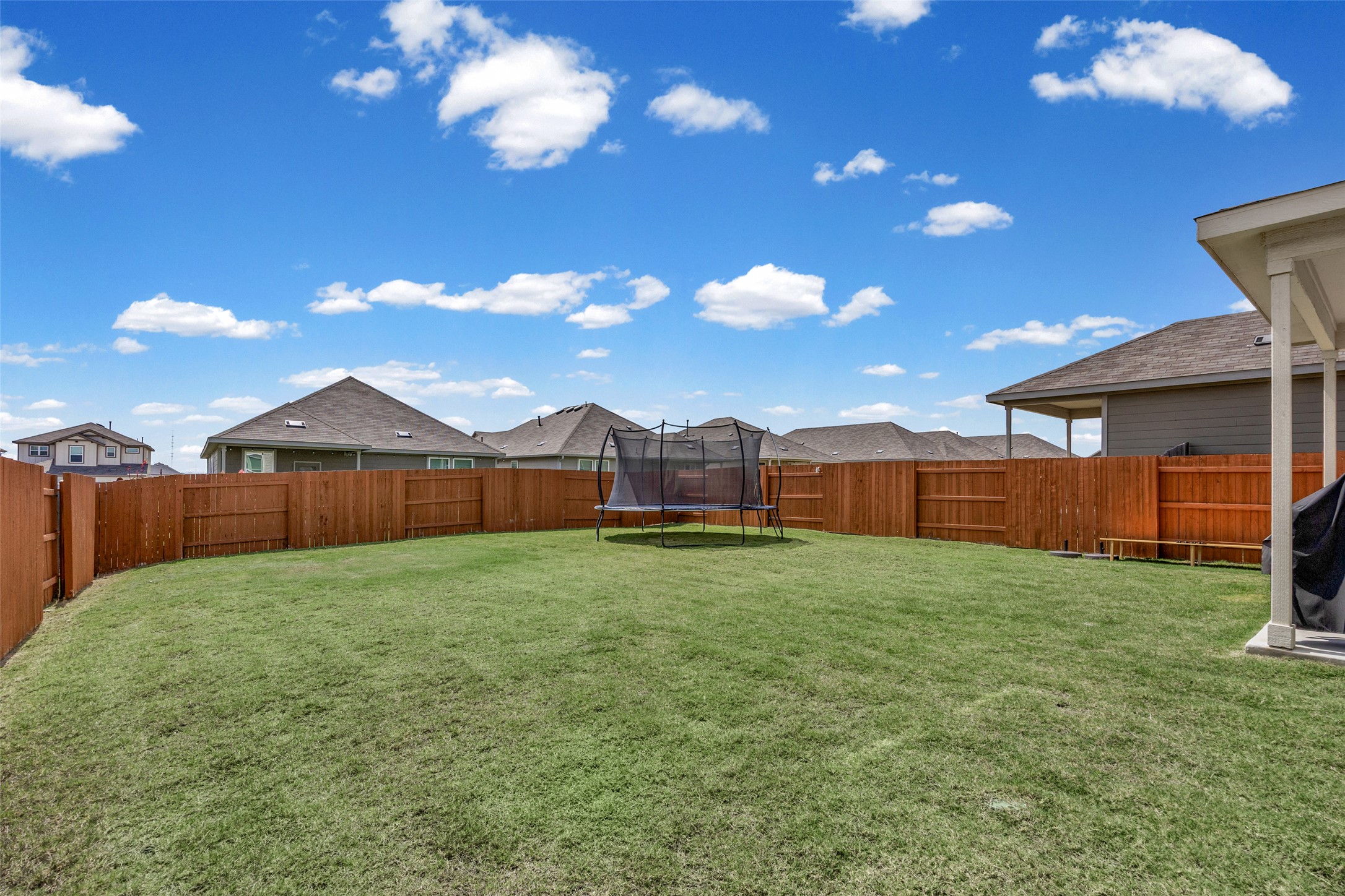 208 Orange Road Buda, TX 78610 - Photo 7 of 31 A well-maintained fenced yard offers a private outdoor space for leisure and play.