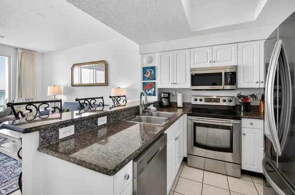 a kitchen with stainless steel appliances granite countertop a sink stove and microwave