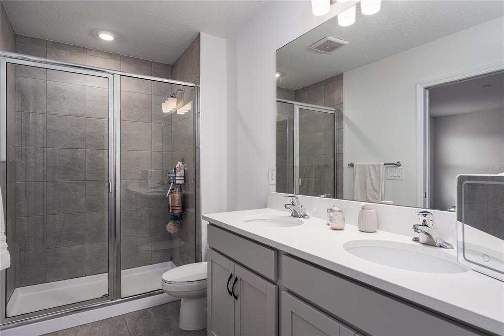 1912 Swivel Lane Sarasota, FL 34240 - Photo 18 of 48 a bathroom with a double vanity sink toilet and shower