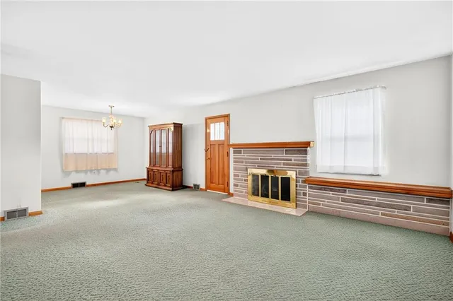 wooden floor fireplace and windows in an empty room
