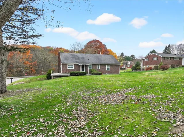 a view of a backyard with table and chairs potted plants and large tree