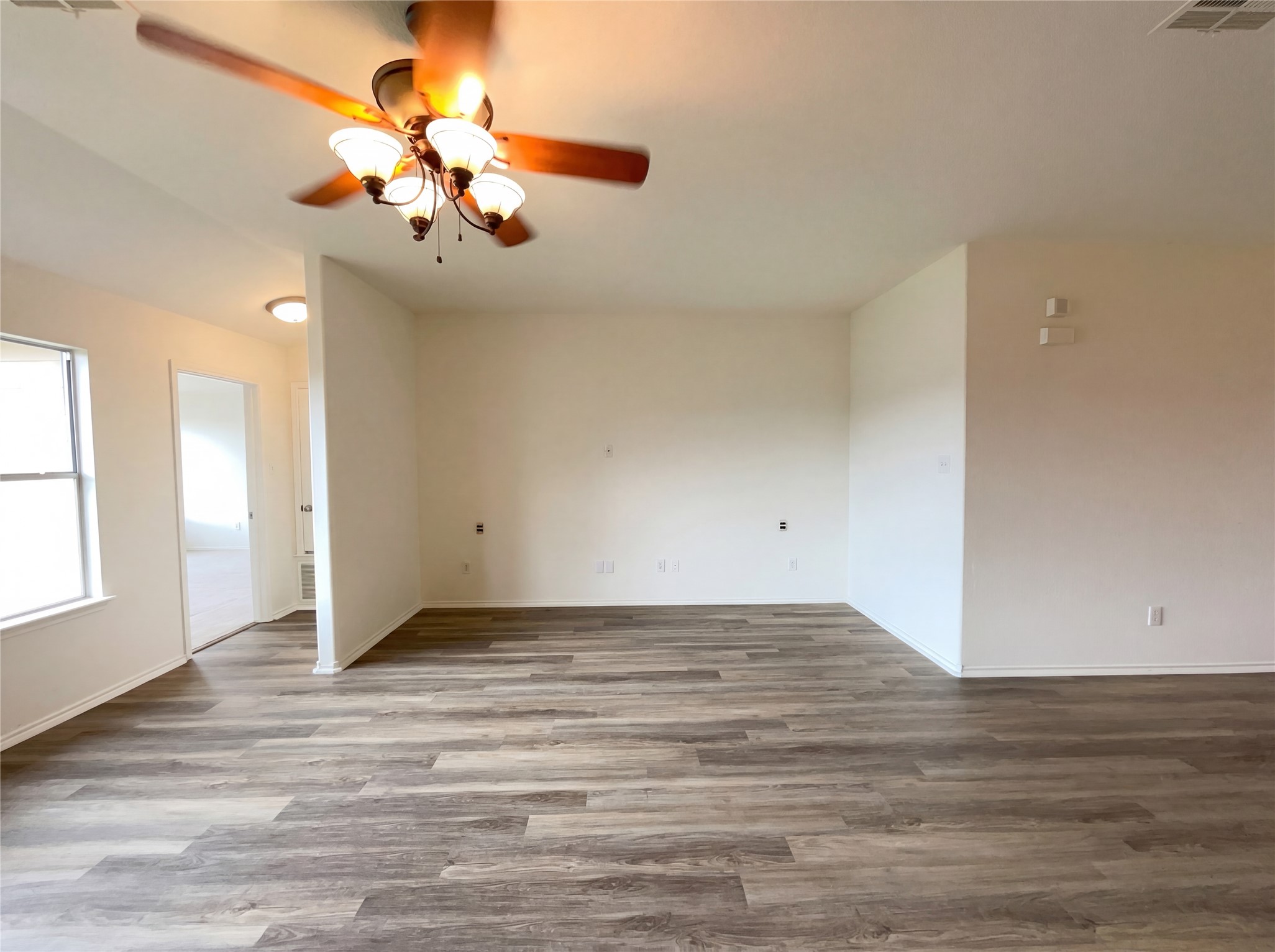 506 Gettysburg Loop Elgin, TX 78621 - Photo 16 of 39 a view of an empty room with wooden floor and a chandelier fan