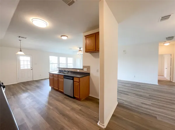 a large kitchen with granite countertop a large counter top space and stainless steel appliances