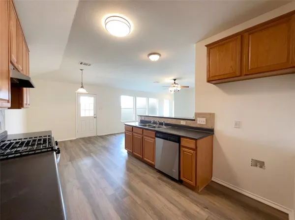 a kitchen with granite countertop a stove and a wooden floors
