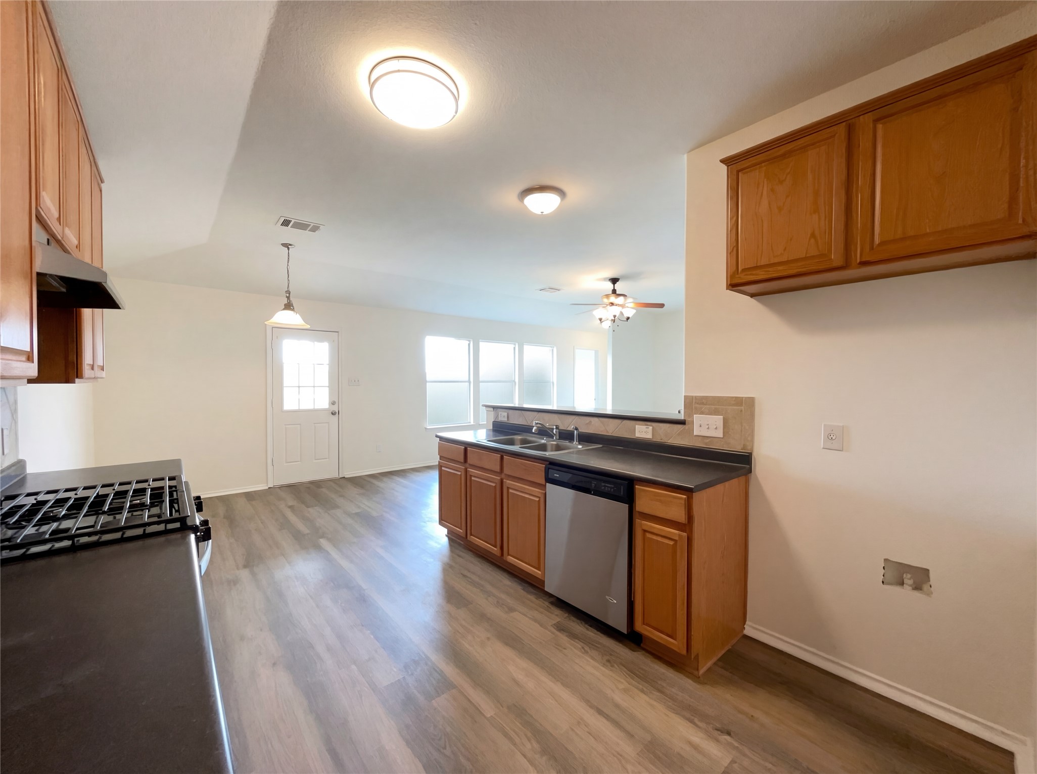 506 Gettysburg Loop Elgin, TX 78621 - Photo 19 of 39 a kitchen with granite countertop a stove and a wooden floors