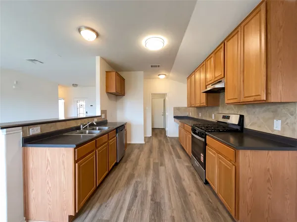 a kitchen with stainless steel appliances granite countertop a stove a sink and a refrigerator