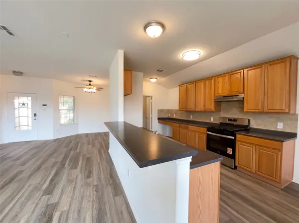 a kitchen with stainless steel appliances granite countertop a stove a sink and a refrigerator