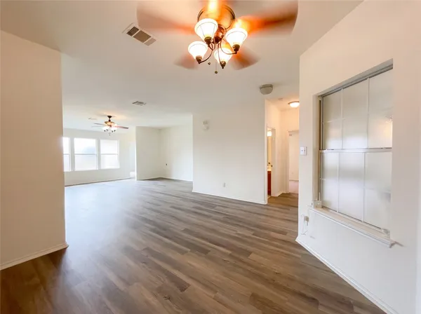 an empty room with a window and a ceiling fan