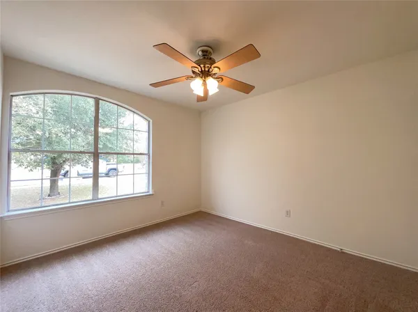a view of a room with a ceiling fan and a window