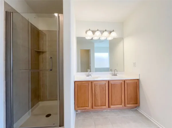 a bathroom with a double vanity sink mirror and shower