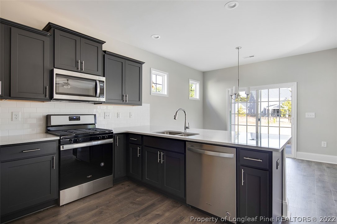 416 Kerr Lake Road Aberdeen, NC 28315 - Photo 16 of 45 a kitchen with stainless steel appliances granite countertop a stove a sink dishwasher and microwave