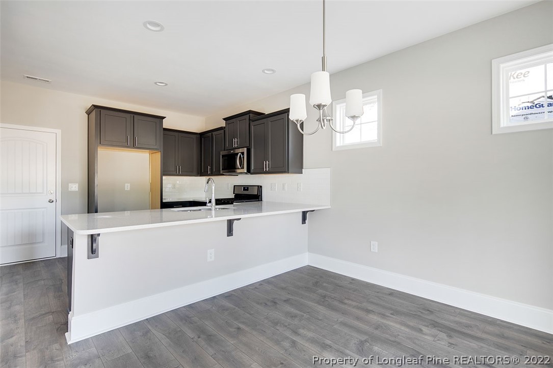 416 Kerr Lake Road Aberdeen, NC 28315 - Photo 20 of 45 a kitchen with cabinets wooden floor and stainless steel appliances