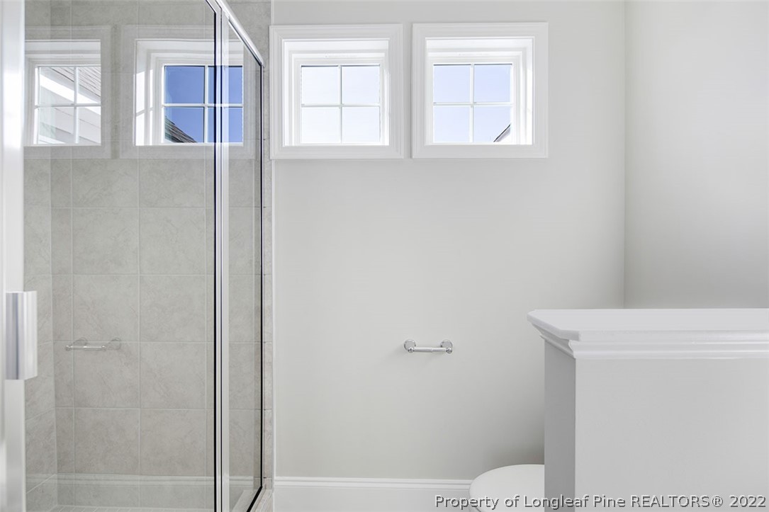 416 Kerr Lake Road Aberdeen, NC 28315 - Photo 29 of 45 a bathroom with a window a toilet and a shower