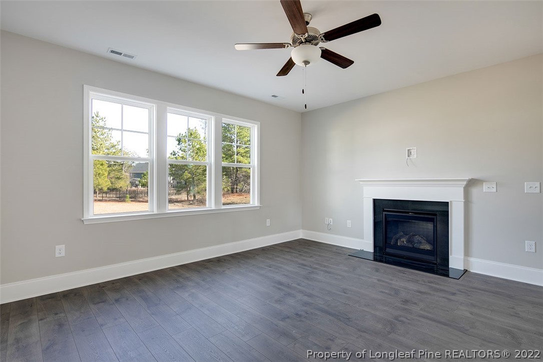 416 Kerr Lake Road Aberdeen, NC 28315 - Photo 10 of 45 a view of an empty room with wooden floor fireplace and a window