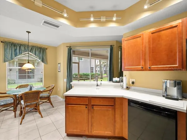 a kitchen with a refrigerator a sink dishwasher with a dining table and chairs