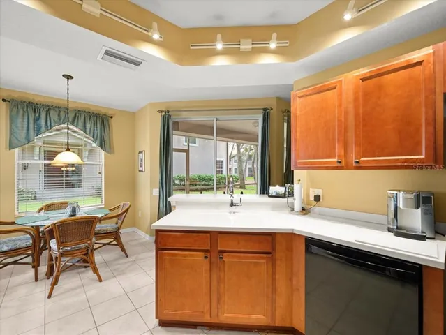 a kitchen with a refrigerator a sink dishwasher with a dining table and chairs