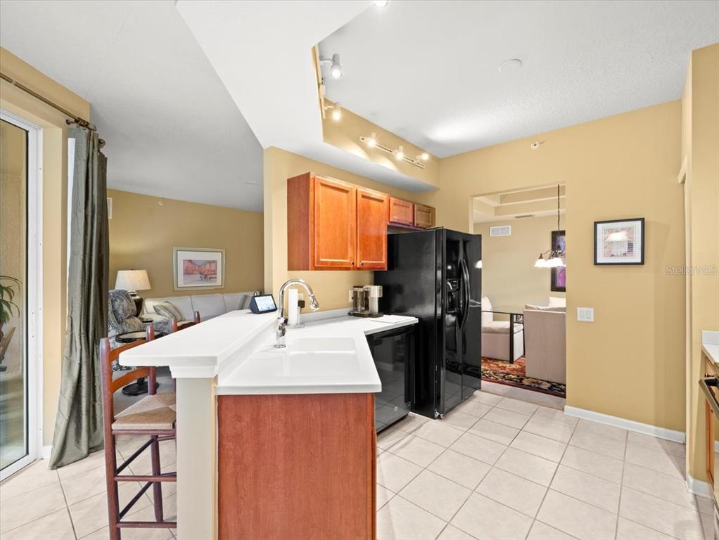 897 Lantern Way Clearwater, FL 33765 - Photo 26 of 56 a kitchen with a refrigerator a sink dishwasher with a dining table and chairs