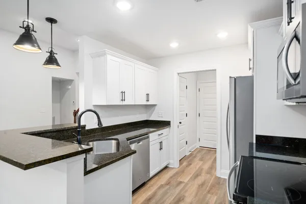 a kitchen with stainless steel appliances granite countertop a sink a stove and a refrigerator