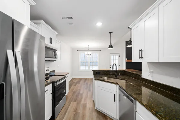 a view of a kitchen with a dishwasher cabinets and a wooden floor
