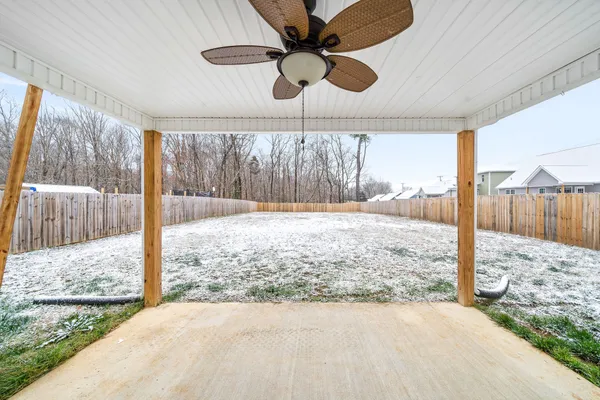 a view of a dry yard with wooden fence