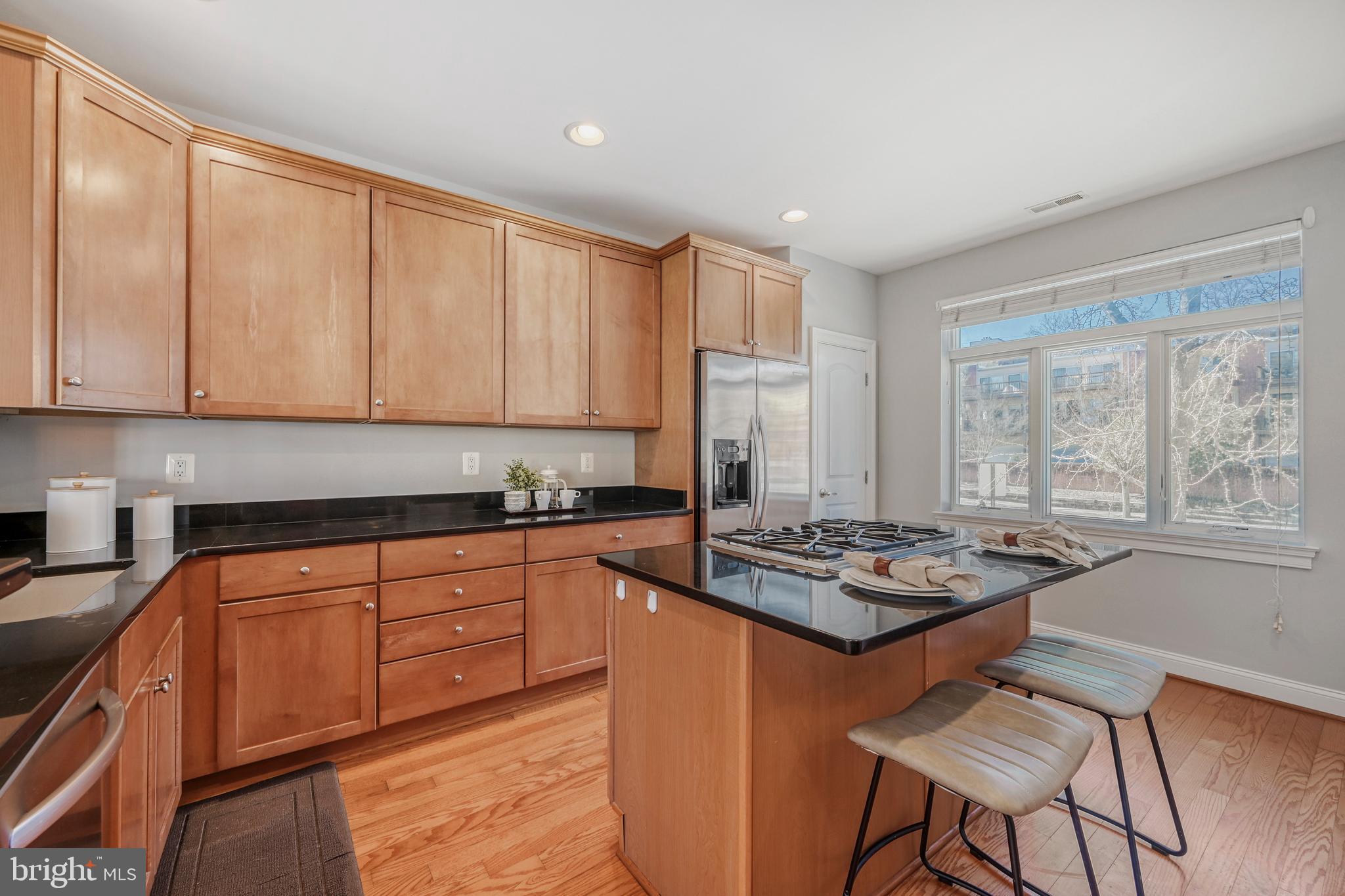 900 Valencia Court, Unit 188 Baltimore, MD 21230 - Photo 22 of 46 a kitchen with stainless steel appliances granite countertop a stove a sink dishwasher and cabinets with wooden floor