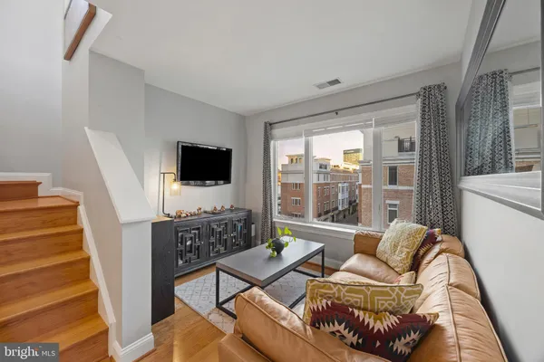 a living room with furniture a flat screen tv and a floor to ceiling window