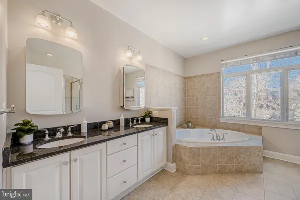 a spacious bathroom with a granite countertop tub sink and mirror