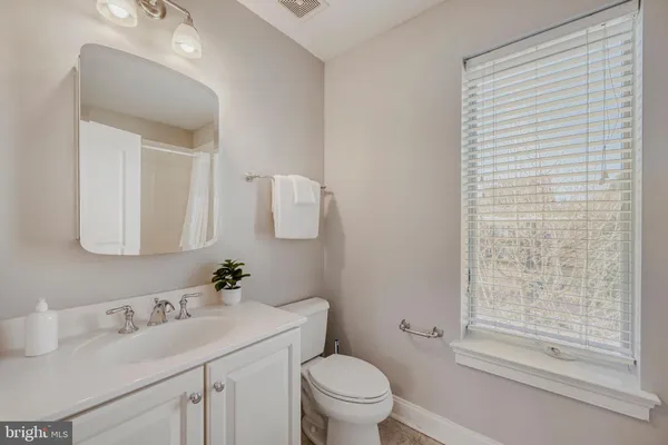 a bathroom with a sink vanity mirror and toilet