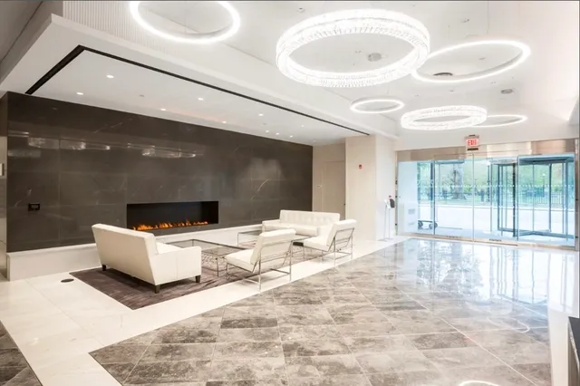 a living room with a large window and white furniture