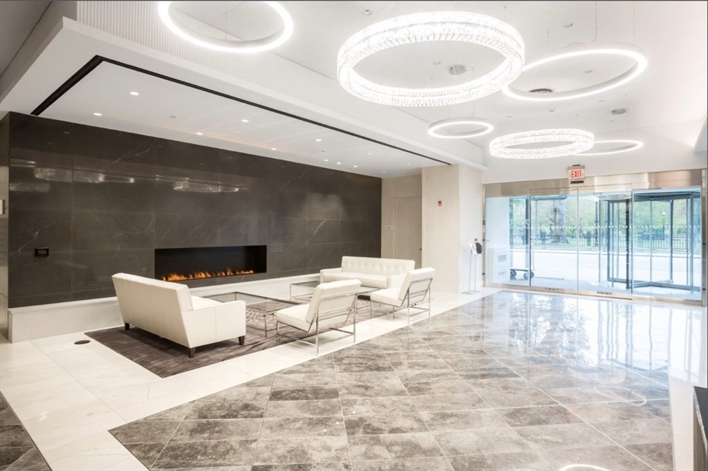 151 Tremont Street, Unit 9S Boston, MA 02111 - Photo 4 of 11 a living room with a large window and white furniture