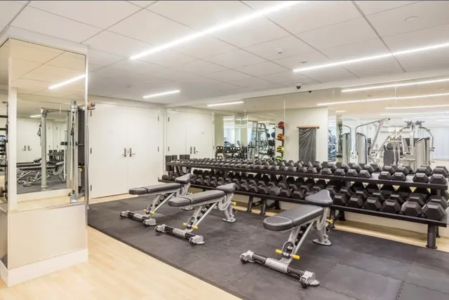 a room with gym equipment and large mirror