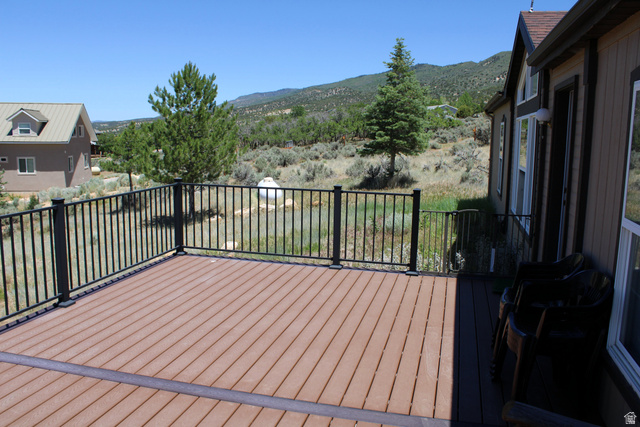 22580 Spring Creek Drive, Unit B61 Fairview, UT 84629 - Photo 7 of 39 Spacious outdoor deck featuring composite decking in a two-tone finish, black metal railing, and a private natural landscape