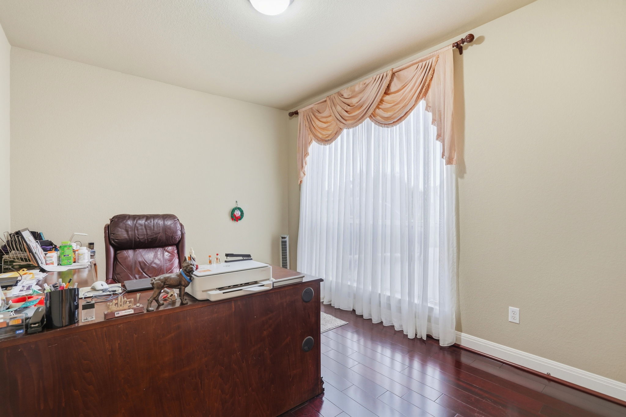 222 Vailco Lane Austin, TX 78738 - Photo 25 of 39 Spacious room featuring wood-finish flooring, light-colored walls, and a large window with sheers and a decorative valance