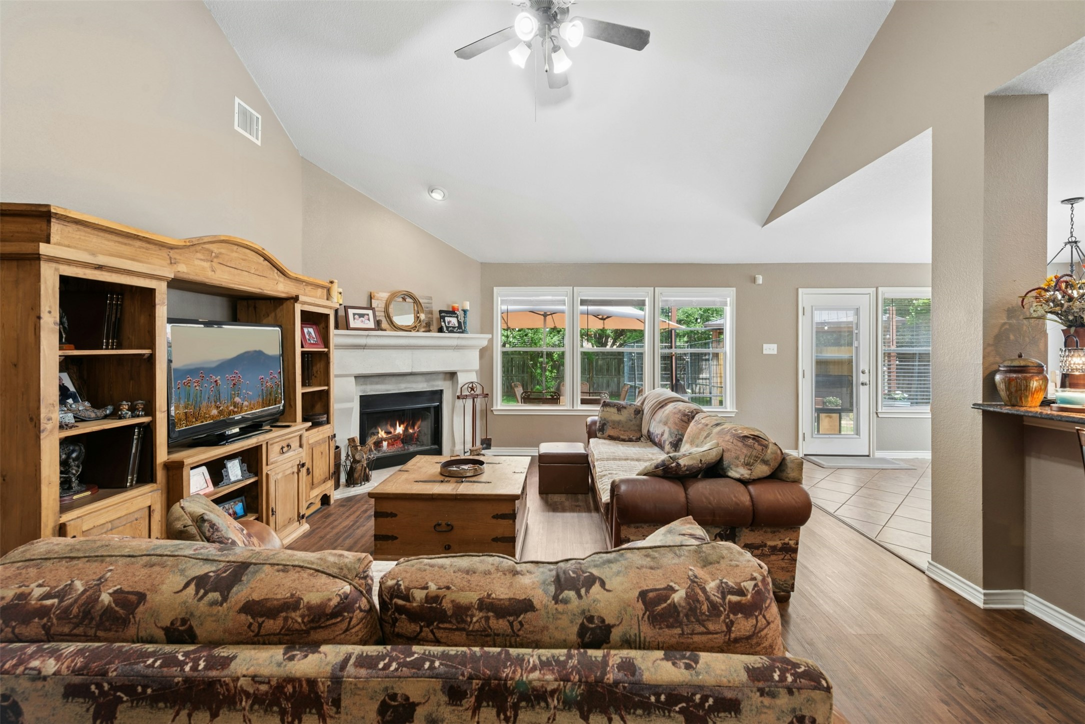 30013 Edgewood Drive Georgetown, TX 78628 - Photo 6 of 39 Spacious living area featuring vaulted ceilings, a fireplace with a stone surround, and large windows providing views of the outdoors