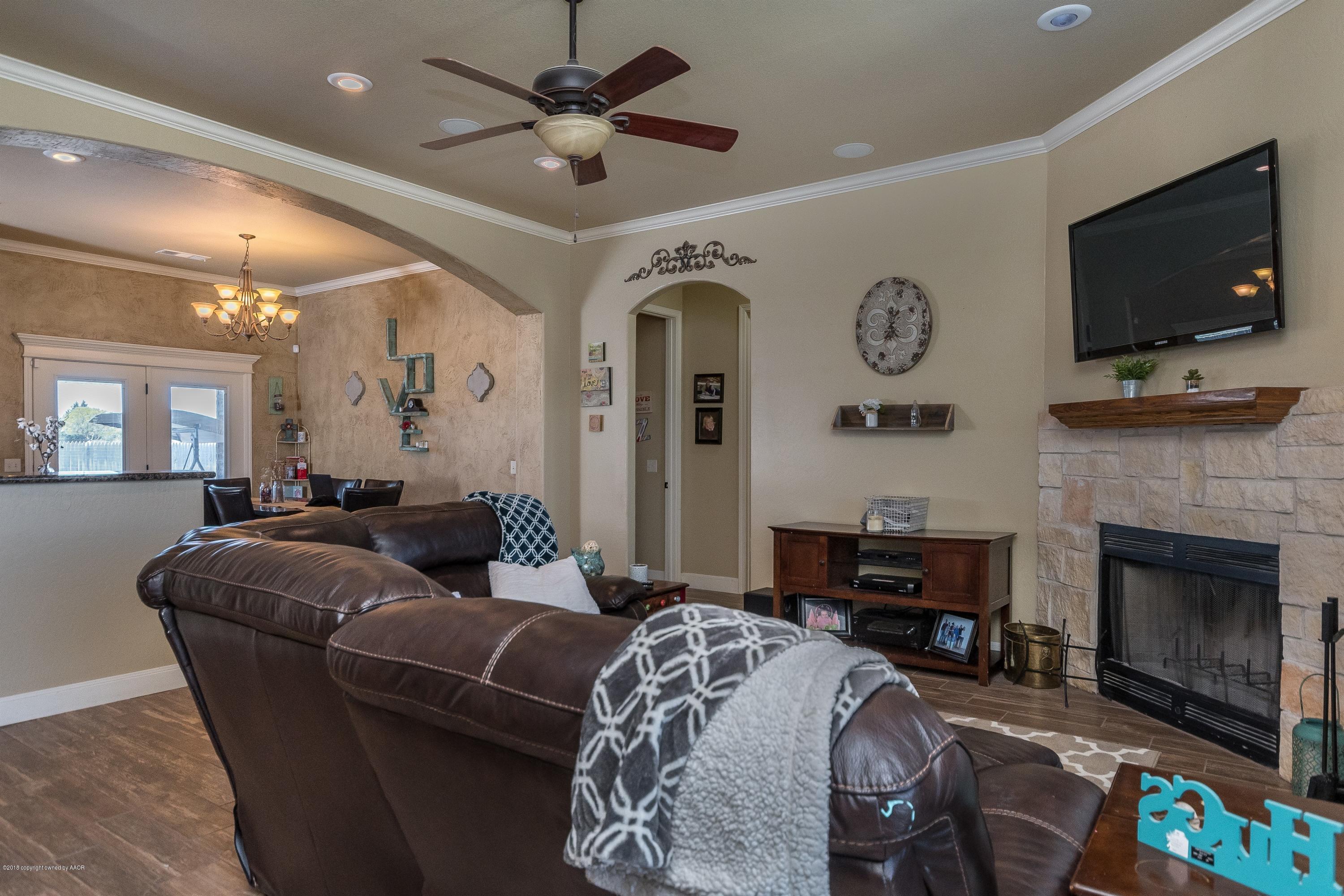 3909 Arden Road Amarillo, TX 79118 - Photo 3 of 20 a living room with furniture a flat screen tv and a fireplace