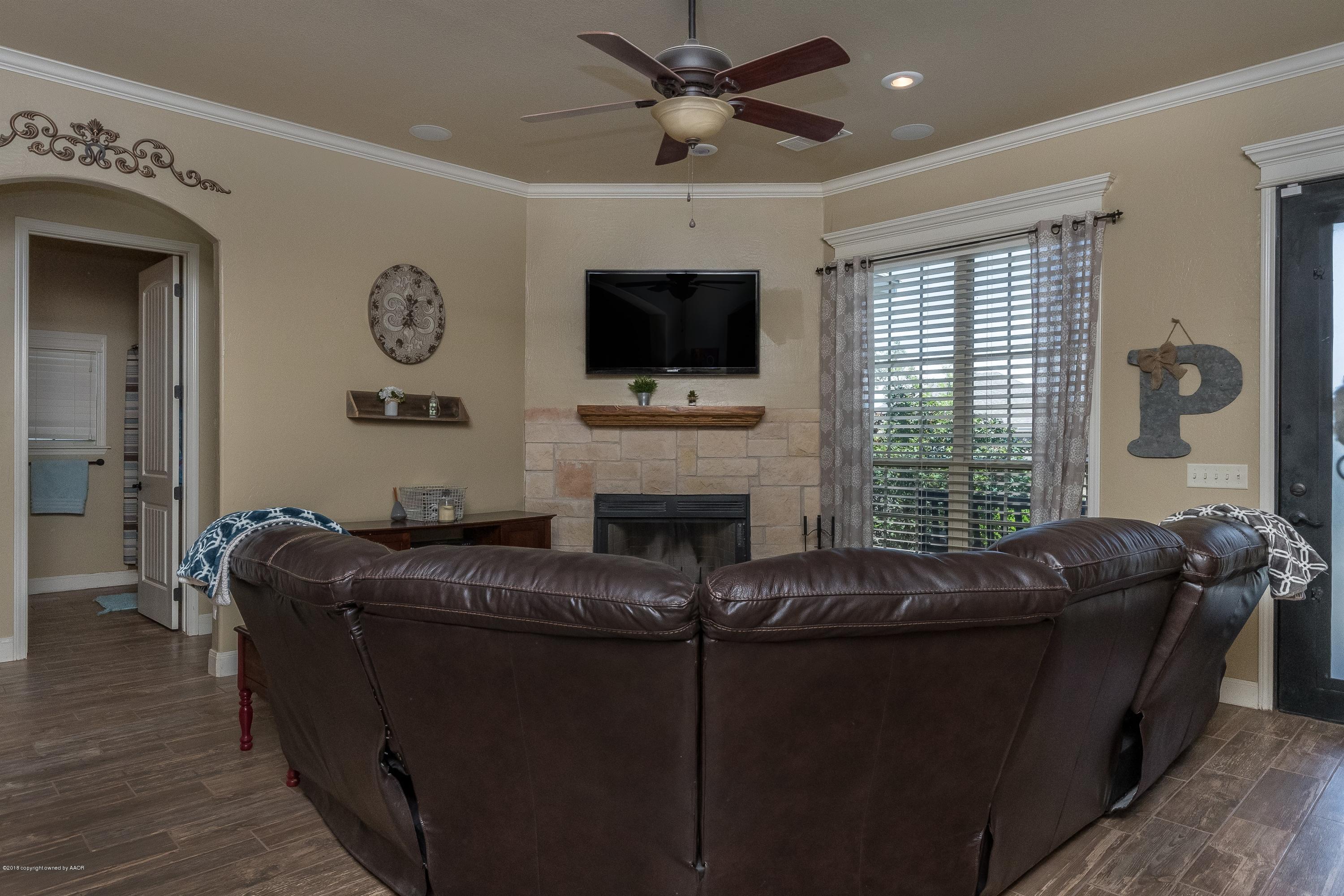 3909 Arden Road Amarillo, TX 79118 - Photo 4 of 20 a living room with furniture a flat screen tv and a fireplace