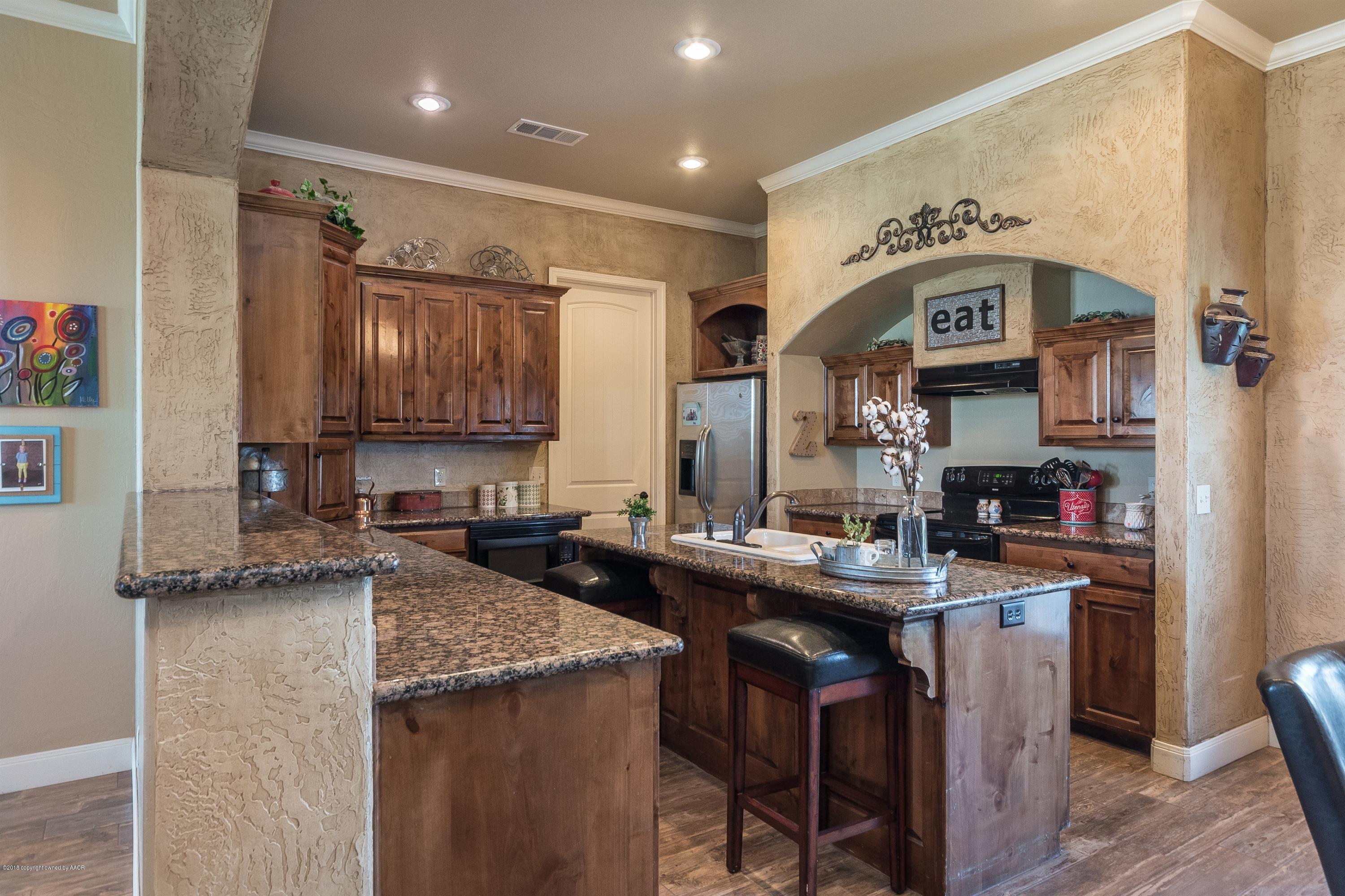 3909 Arden Road Amarillo, TX 79118 - Photo 6 of 20 a kitchen with granite countertop a sink stove and cabinets