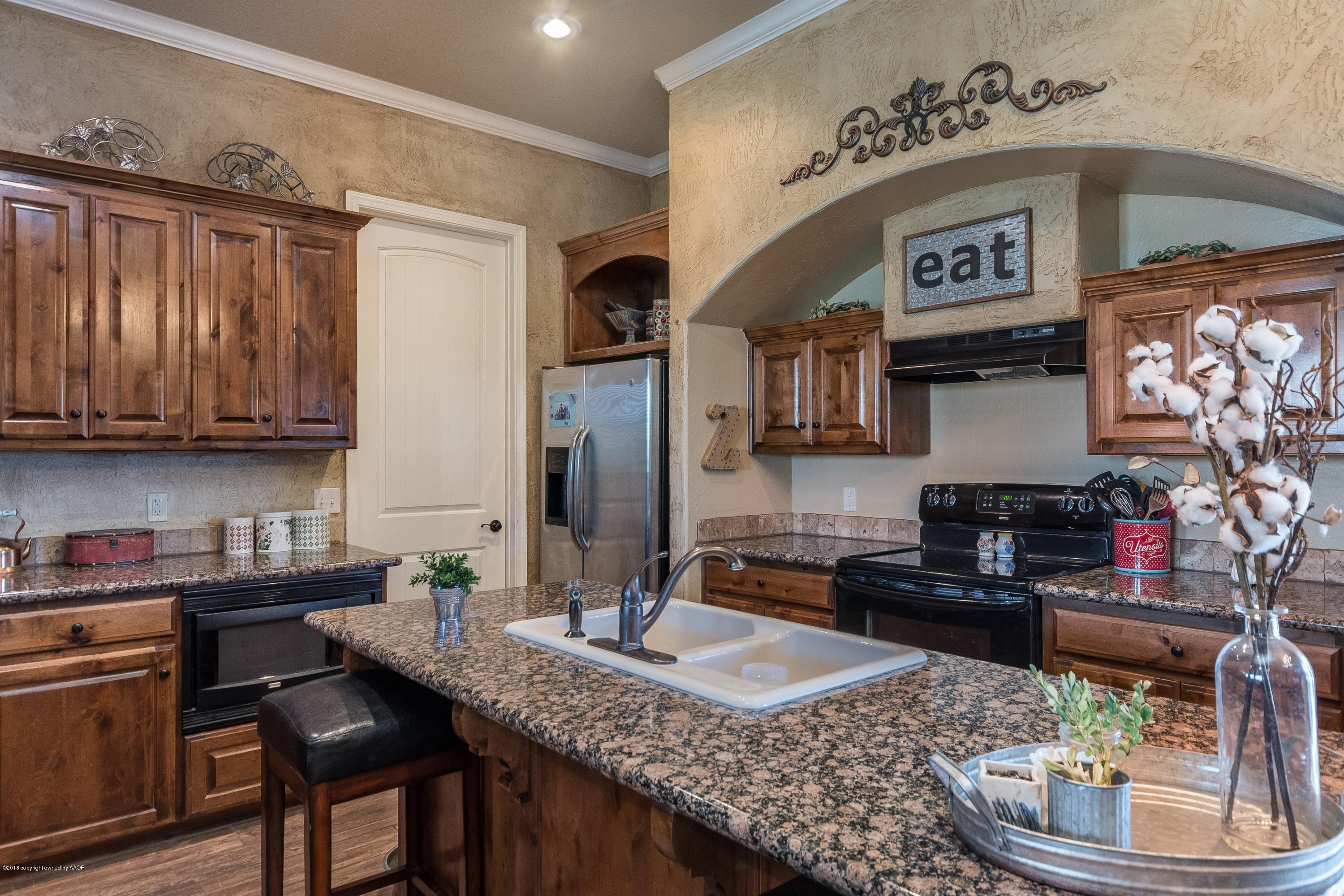 3909 Arden Road Amarillo, TX 79118 - Photo 7 of 20 a kitchen with stainless steel appliances granite countertop a sink a stove and a wooden cabinets