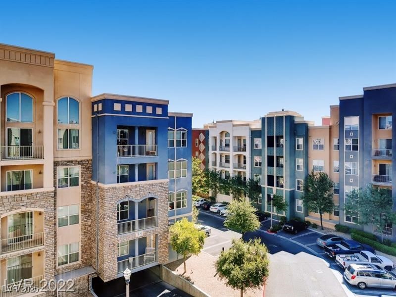 View of apartment building / complex featuring uncovered parking