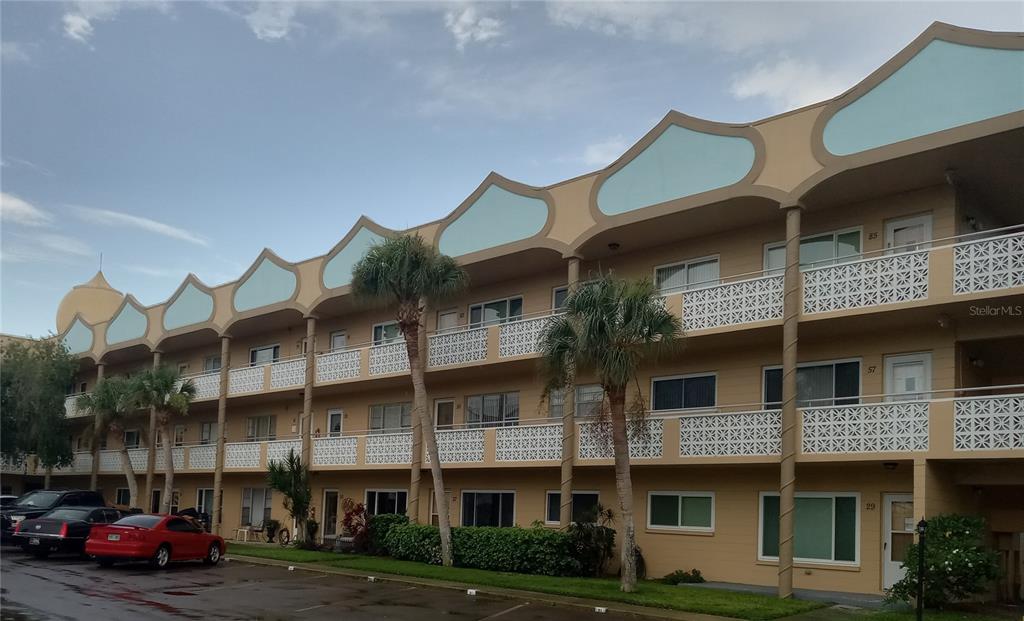 2467 Finlandia Lane, Unit 27 Clearwater, FL 33763 - Photo 1 of 58 a front view of a building with lot of cars and trees