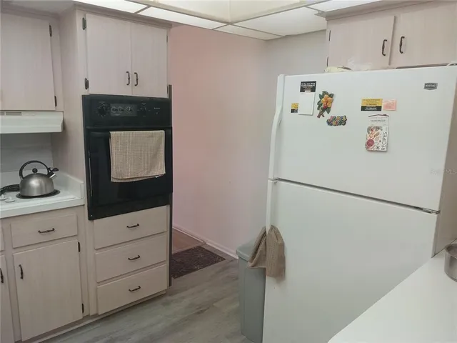 a kitchen with white cabinets and sink