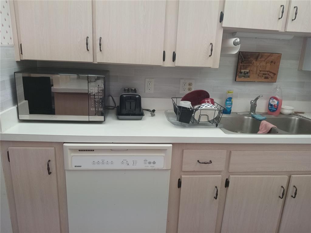 2467 Finlandia Lane, Unit 27 Clearwater, FL 33763 - Photo 17 of 58 a kitchen with a refrigerator and cabinets