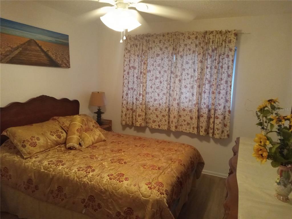 2467 Finlandia Lane, Unit 27 Clearwater, FL 33763 - Photo 32 of 58 a bedroom with a bed and a chandelier