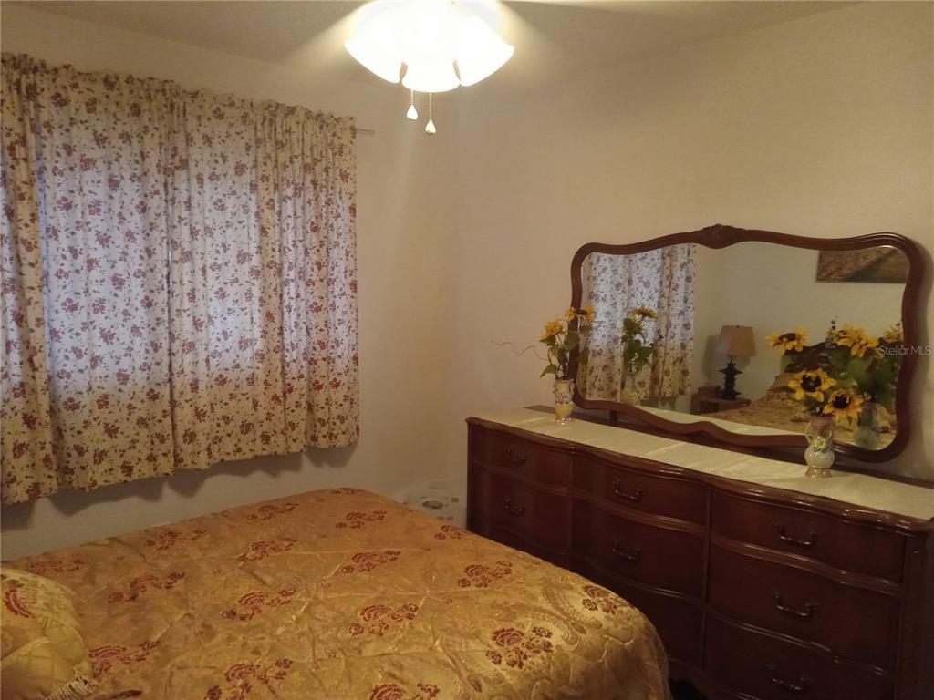2467 Finlandia Lane, Unit 27 Clearwater, FL 33763 - Photo 34 of 58 a bedroom with a bed and a mirror on dresser