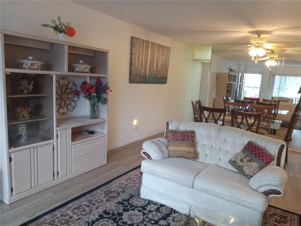 2467 Finlandia Lane, Unit 27 Clearwater, FL 33763 - Photo 6 of 58 a living room with furniture and a chandelier