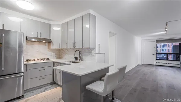 a kitchen with stainless steel appliances granite countertop a sink stove and refrigerator