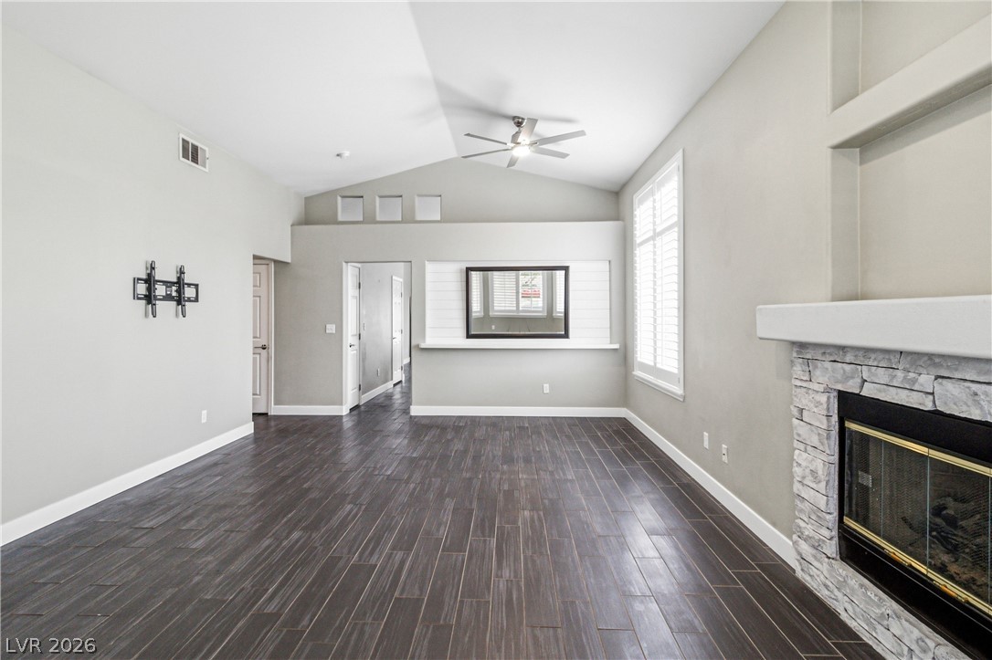 9523 Observer Street Las Vegas, NV 89123 - Photo 8 of 42 A fireplace with stone surround anchors this expansive living area, complemented by a ceiling fan for comfort.