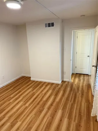 a view of empty room with wooden floor