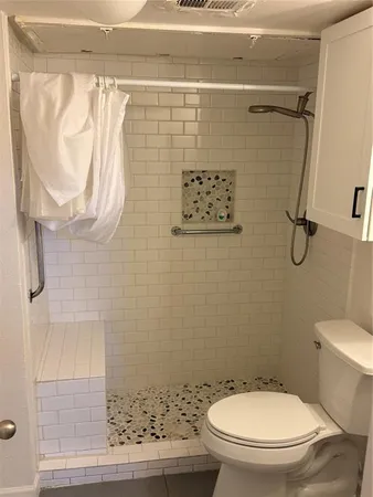 a bathroom with a toilet and a shower