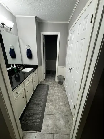 a hallway with white cabinets and wooden floor